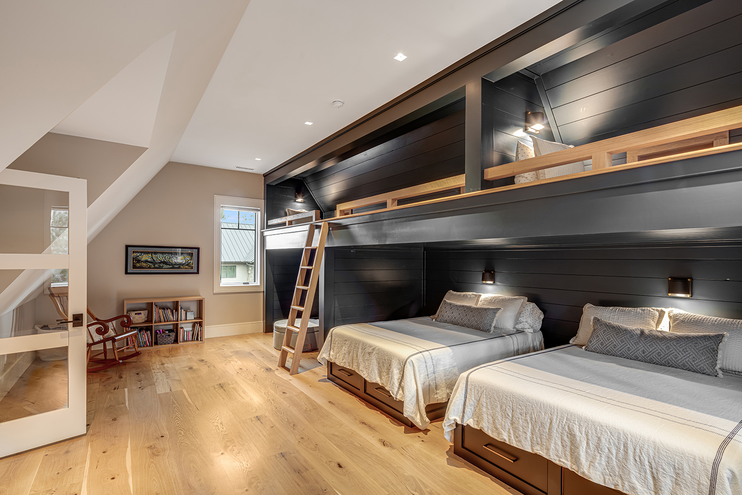 Custom built-in bunk room with dark shiplap feature wall and multiple beds — lake house design by Mac & Morgan Interiors